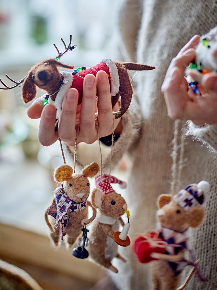 Person holding felt Christmas decorations including wool mice and dachshund ornament
