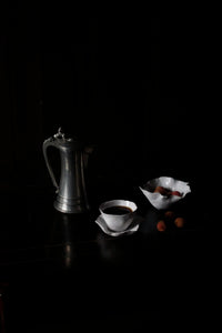 Claire cup and saucer by Olsson & Jensen styled on a dark table with a metal coffee pot