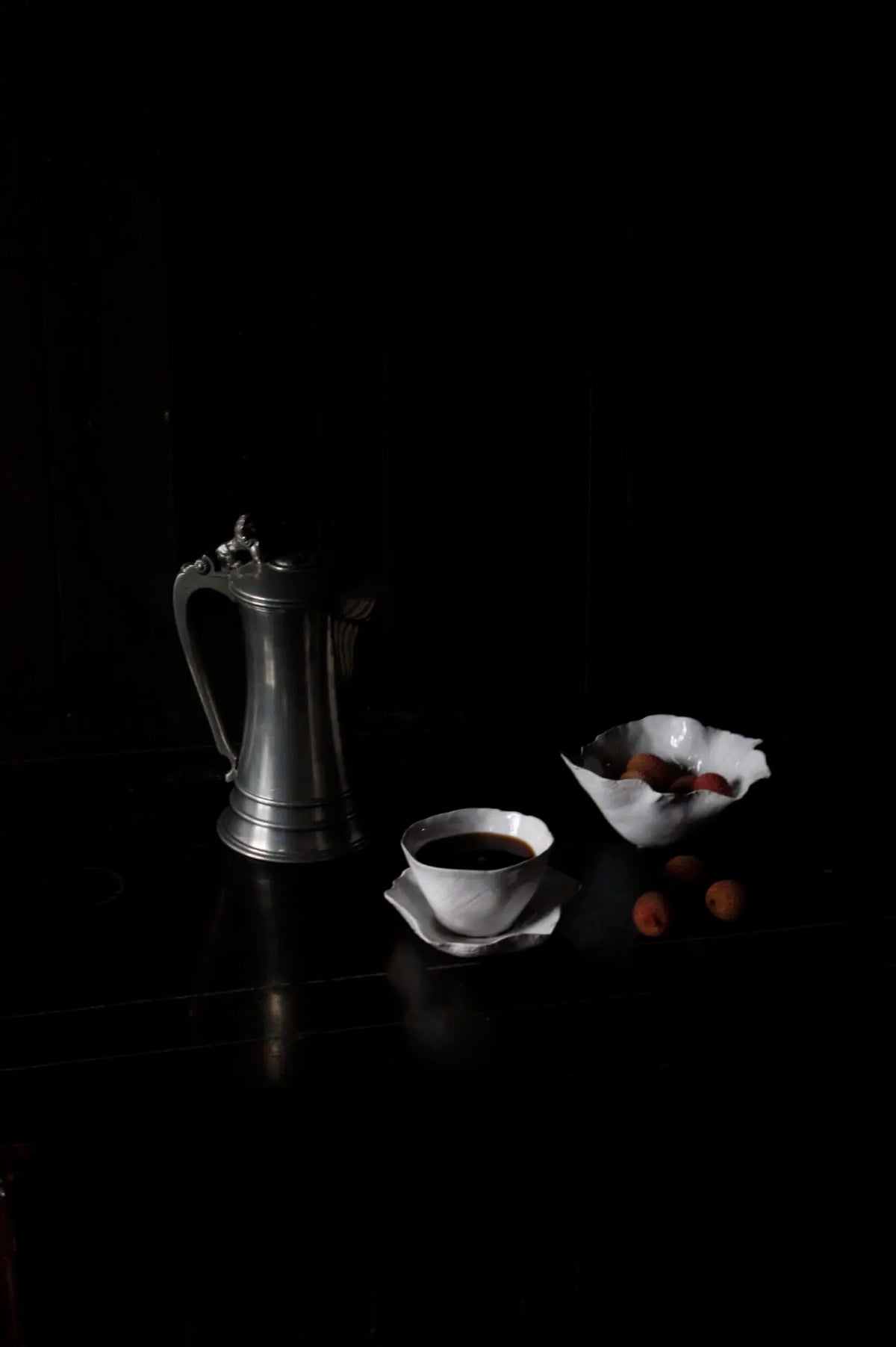 Claire cup and saucer by Olsson & Jensen styled on a dark table with a metal coffee pot
