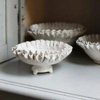 Claudine white ruffled bowls by Olsson & Jensen styled in a painted cabinet