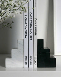 black and white marble staircase bookends holding architecture books
