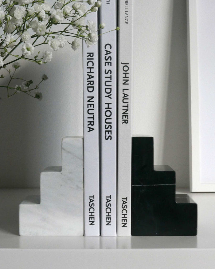 black and white marble staircase bookends holding architecture books

