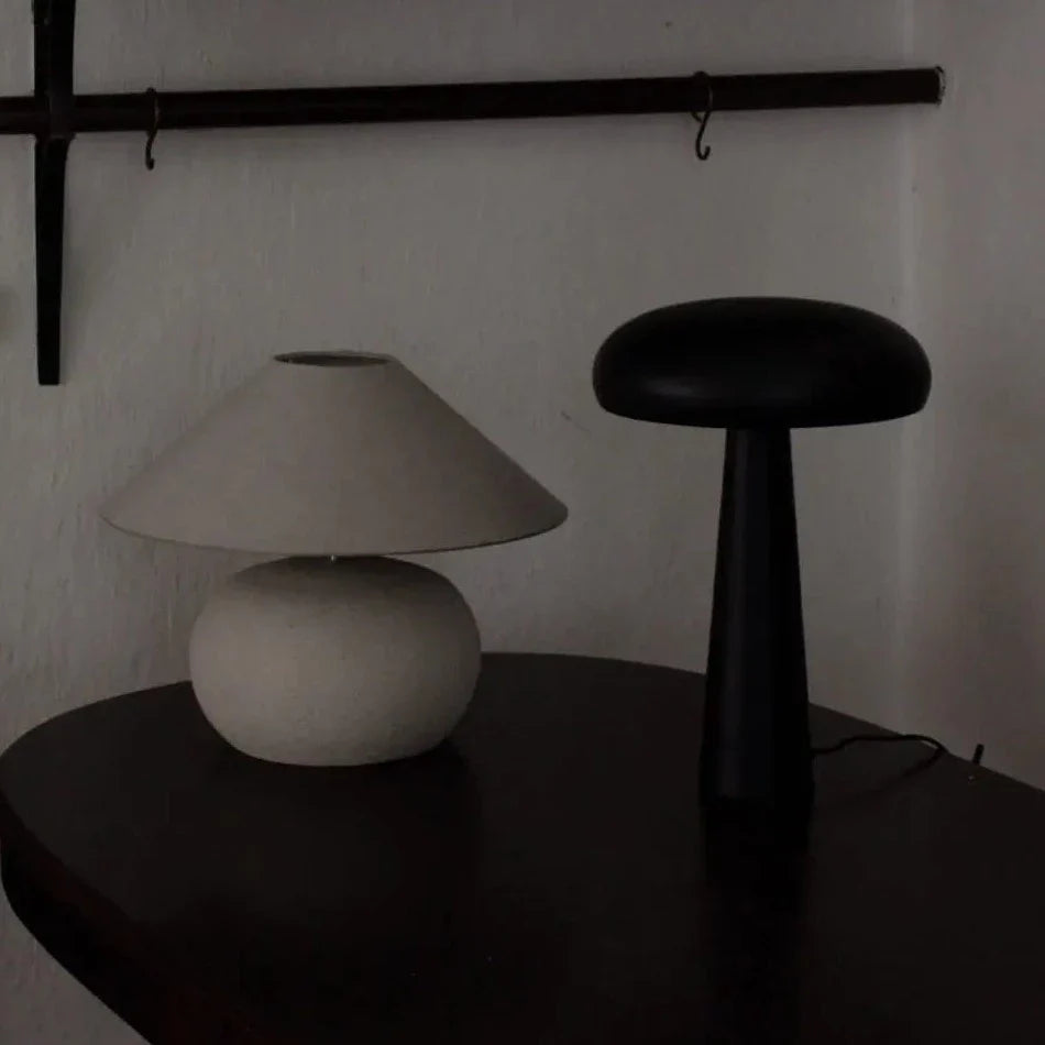 Colmar lamp base by Olsson & Jensen styled with a shade on a dark table beside a black lamp