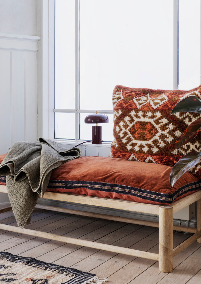 burnt red cotton velvet mattress styled on wooden daybed with patterned cushion