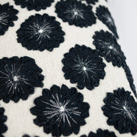 Close-up of the black embroidered flowers on the Dahlia cushion by Olsson & Jensen