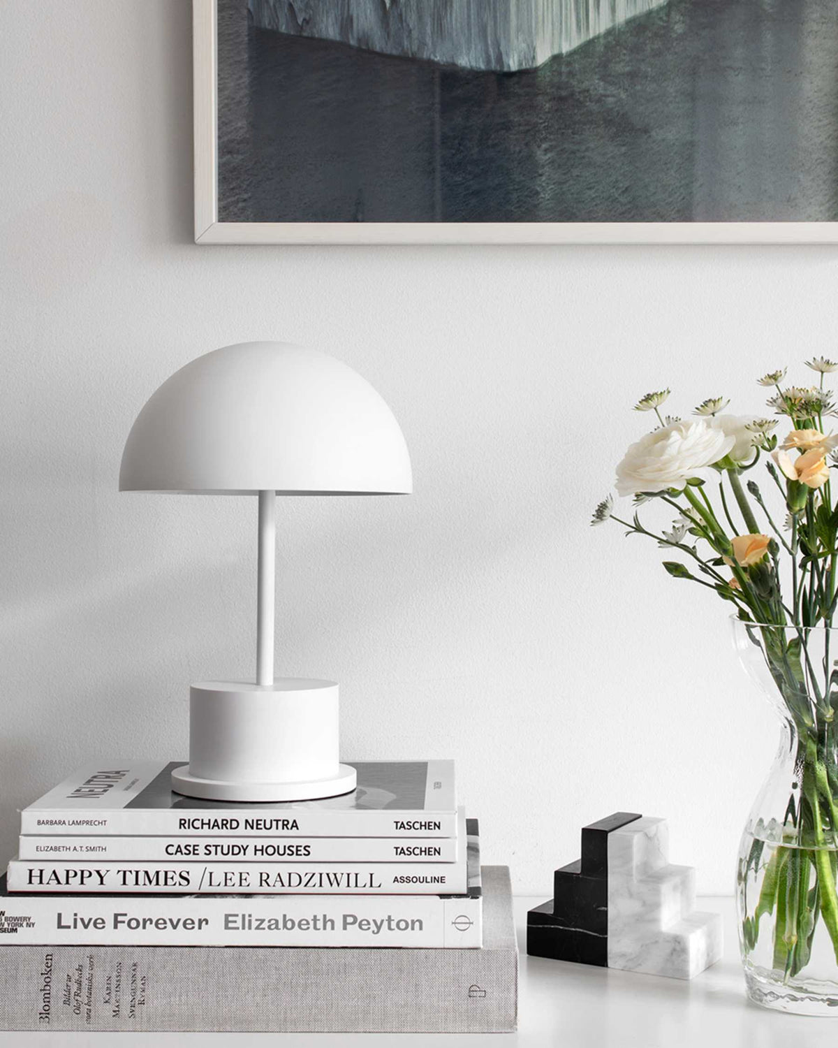 white dome portable lamp creating ambient light on a stack of books
