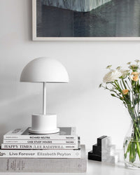 white dome portable lamp creating ambient light on a stack of books
