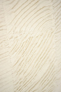 Close-up of the wave-like raw-edged cotton texture on the Elba cushion by Olsson & Jensen