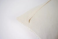 Edge detail of the Elba cream cotton cushion by Olsson & Jensen showing the plain cotton back
