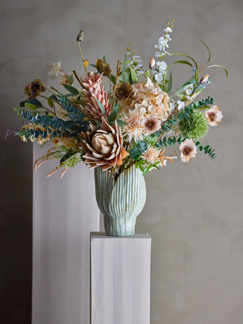 Faux allium flower displayed in mixed arrangement with other stems