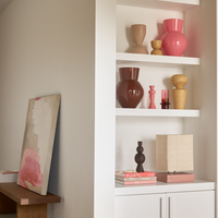 Urban Nature Culture ceramics on a white shelving unit beside a mirror