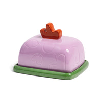 Glossy lilac ceramic butter keeper with playful handle for design-led kitchens.