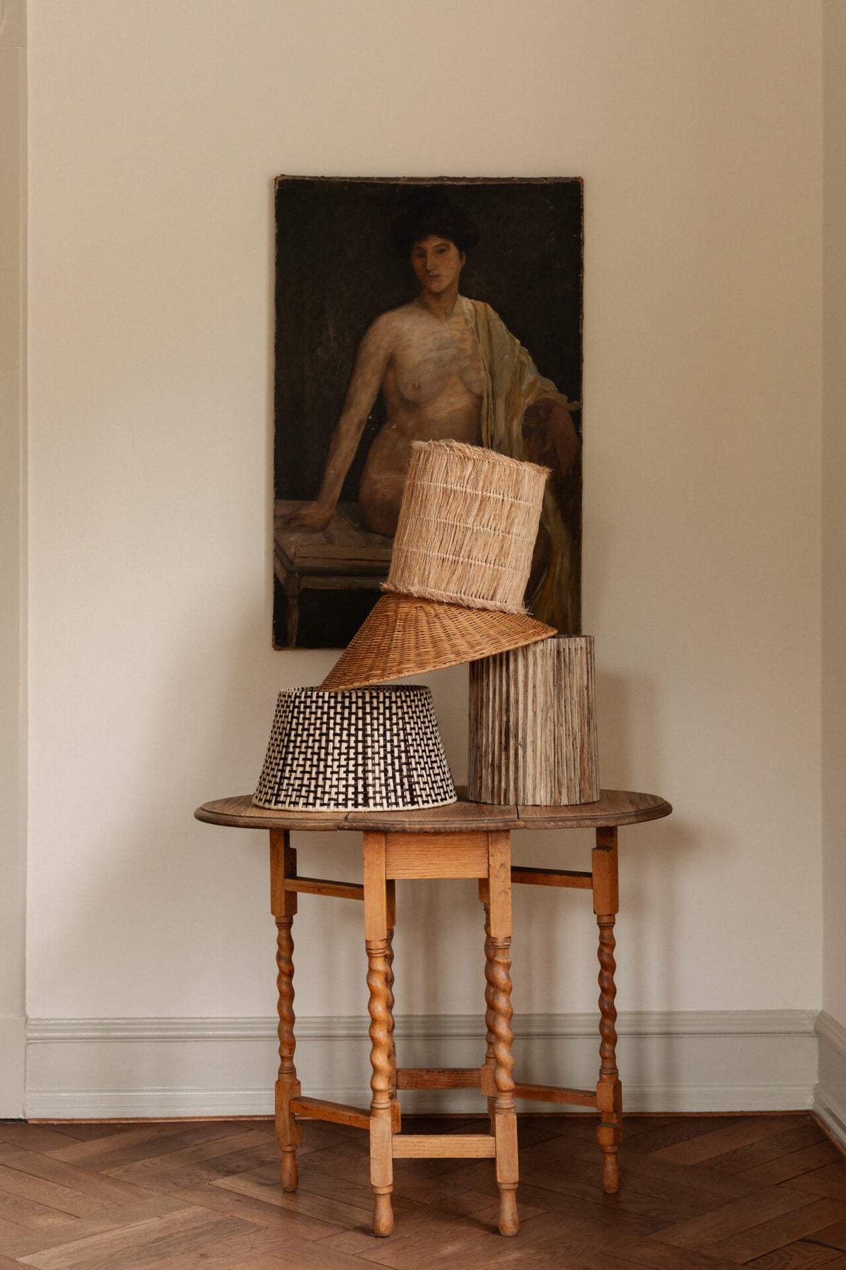 Goa lamp shade by Olsson & Jensen stacked with other shades on a hallway table