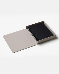 Open grey photo album with black pages on white background