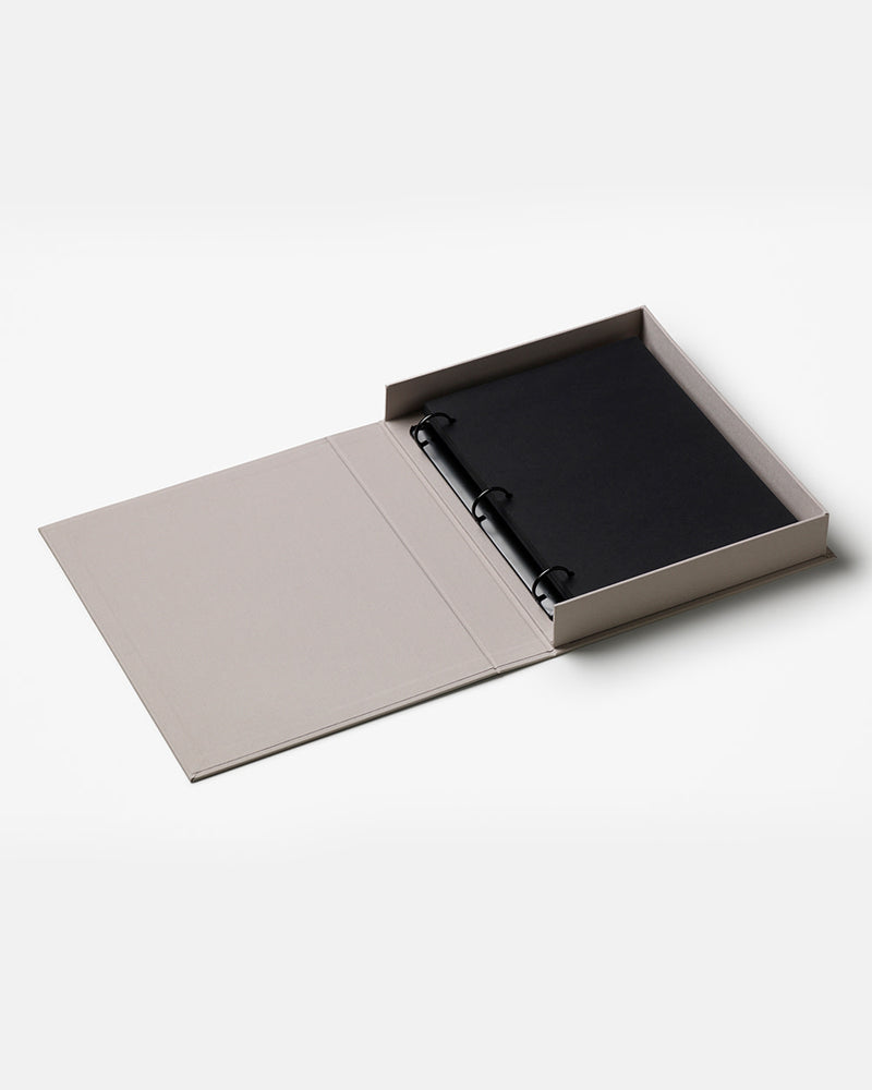Open grey photo album with black pages on white background
