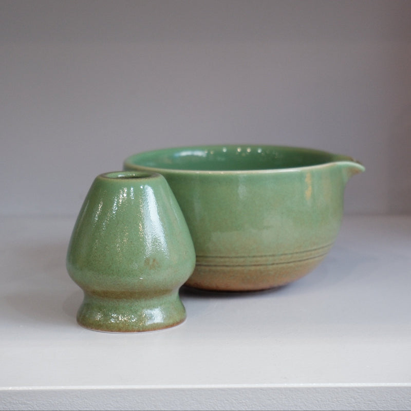 green glazed ceramic matcha bowl with pouring spout and matching whisk stand
