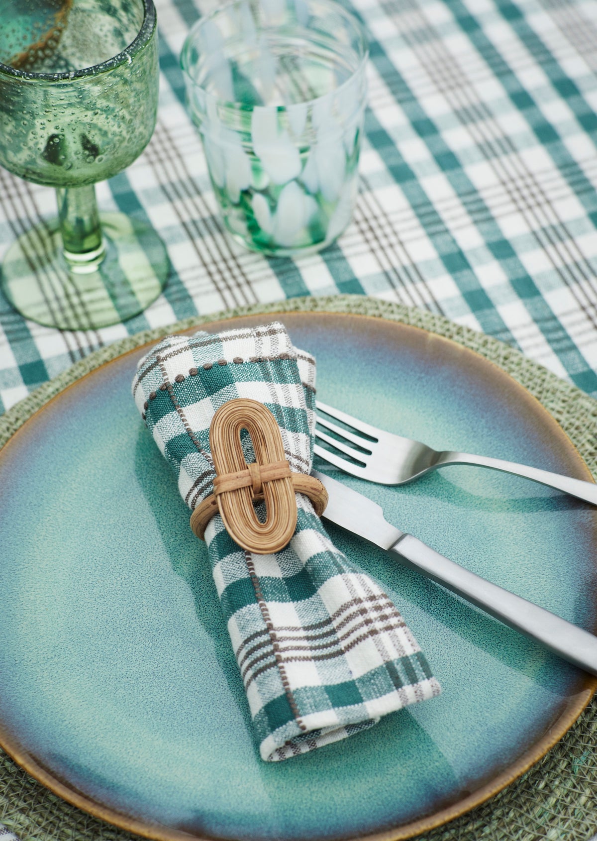 green wine glass styled with blue plate and checked napkin
