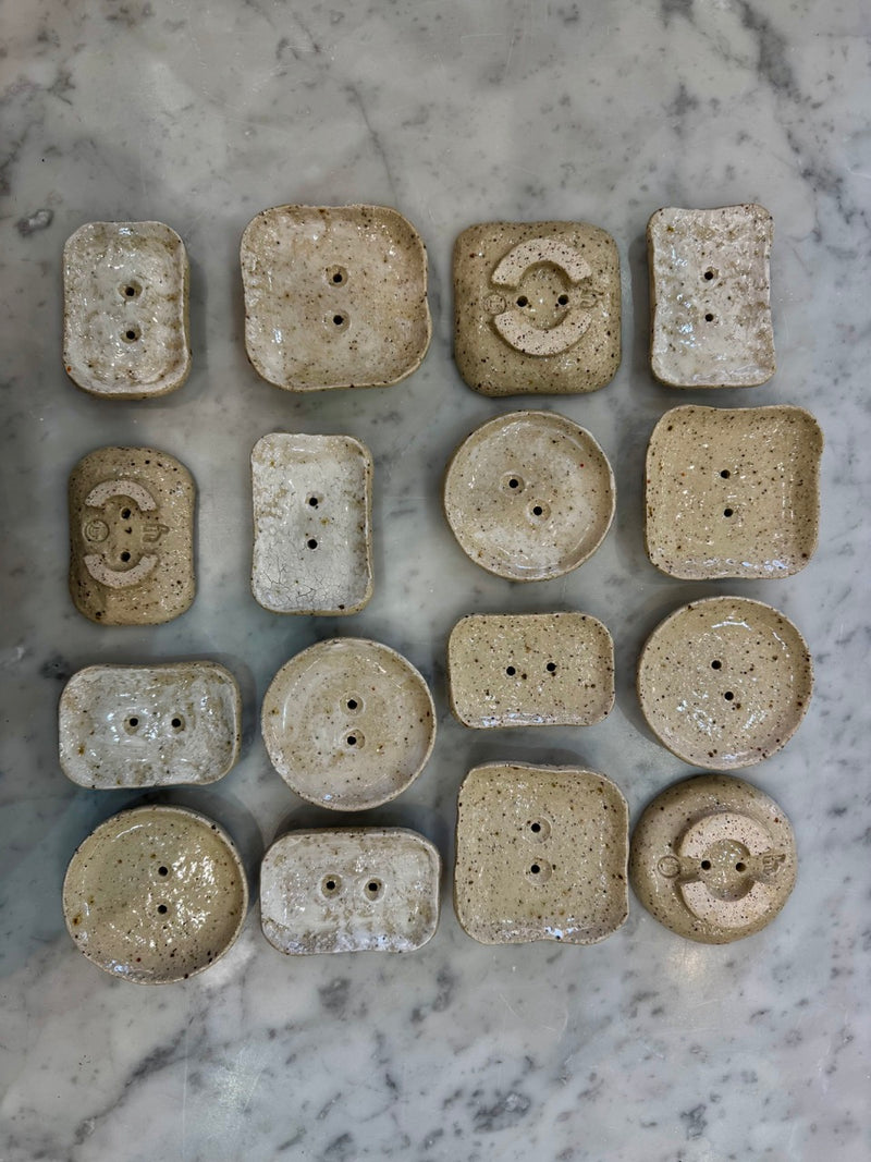 Collection of ceramic soap dishes on a marble surface