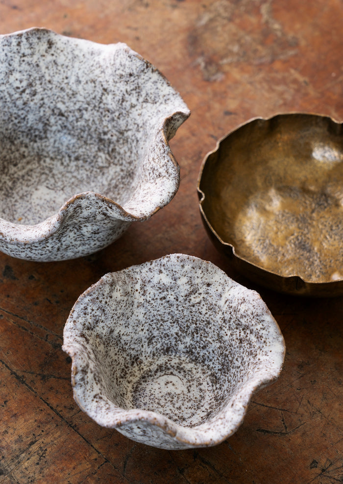 Set of two hand-hammered antique brass aluminium bowls on white background