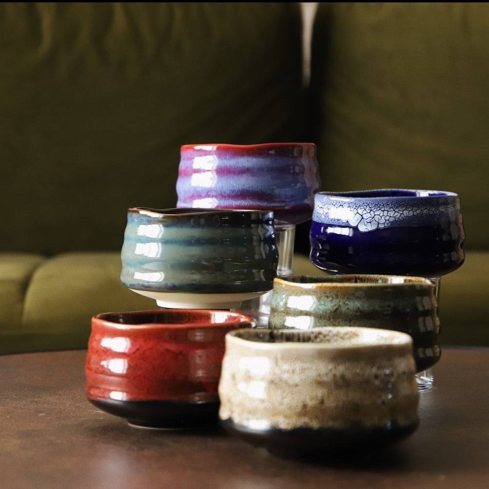 Handmade matcha bowls in a range of glazes including indigo, grouped on a table