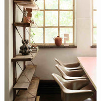 an office or school room setting with very old dusty wooden shelves and a terracotta pot and white wooden object on the windowsill in the background