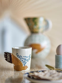 Bloomingville Hezha Blue cup placed on a breakfast table beside an egg cup and ceramic jug.