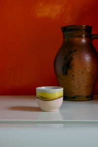 70s ceramics café cup in glint glaze styled on a countertop with warm retro tones
