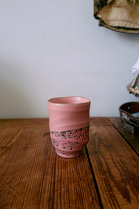 Smooth pink hkliving ceramic mug adding calm, tactile texture to a wooden breakfast table.
