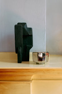 burned black wooden sculpture styled on a mantel for a modern minimalist interior
