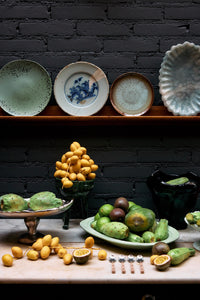 sculptural chrome pedestal plateau by hkliving styled with fruit in a modern industrial kitchen setting
