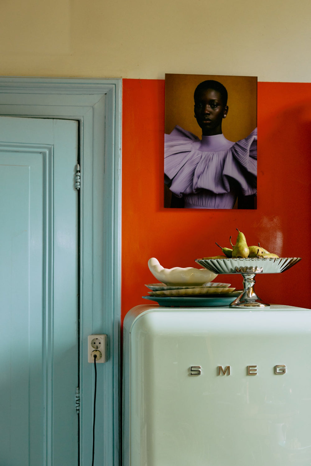 hkliving chrome plateau pedestal stand styled on cabinet against bold orange wall
