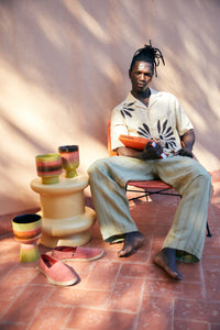 retro ceramic flower pot in fig tones styled beside seating indoors
