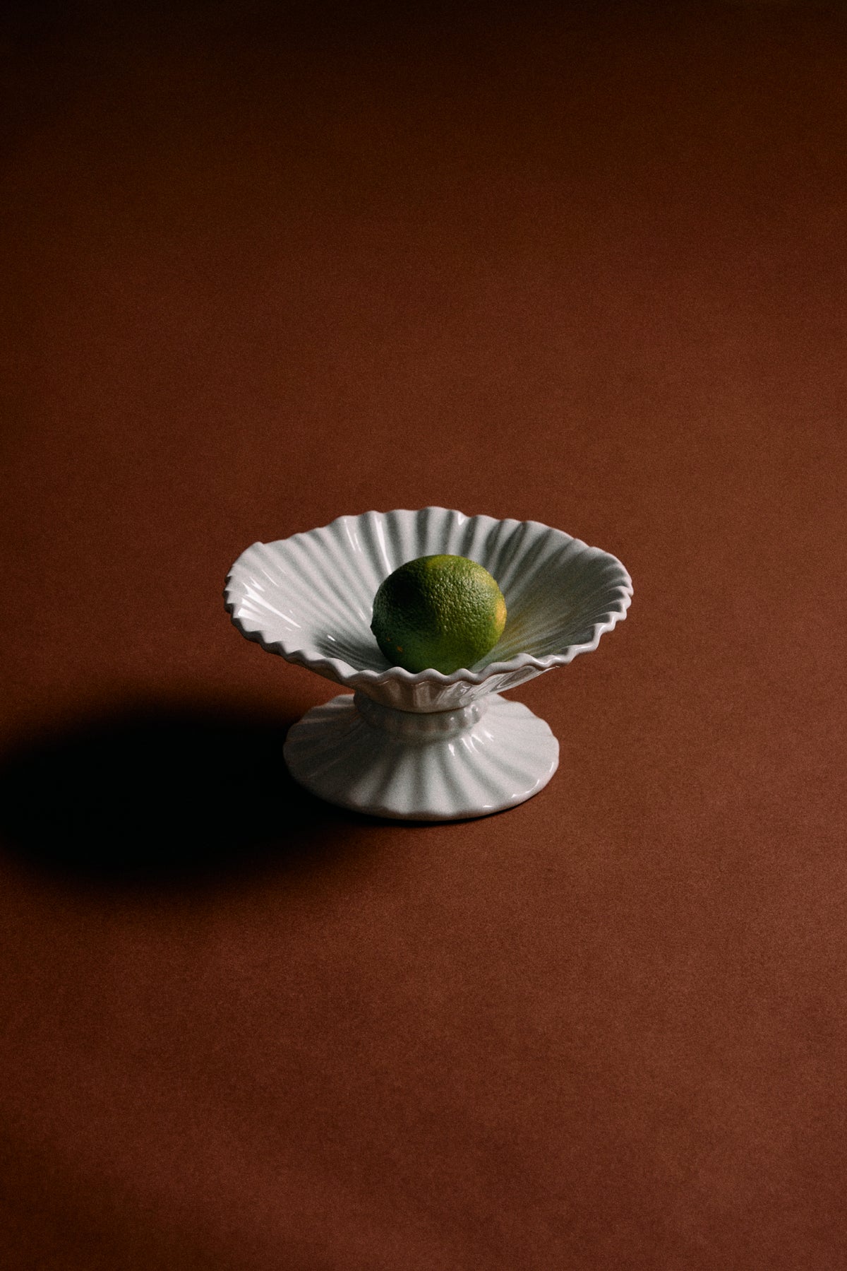 ice blue pedestal ribble bowl by hkliving holding lime as minimalist centrepiece
