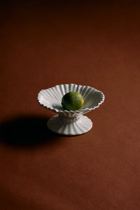 ice blue pedestal ribble bowl by hkliving holding lime as minimalist centrepiece
