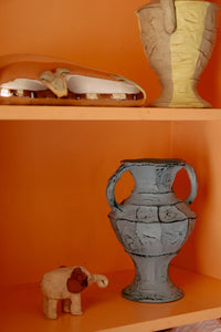 soft blue hkliving vase displayed on shelf with warm orange backdrop for bold contrast styling
