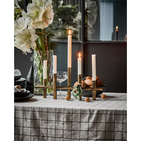 antique brass candle holder styled on festive dining table with tall taper candles