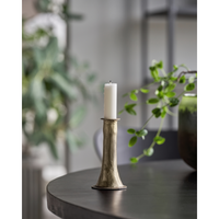 medium antique gold candle holder styled on table with taper candle in calm Nordic interior