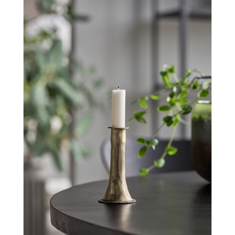 medium antique gold candle holder styled on table with taper candle in calm Nordic interior