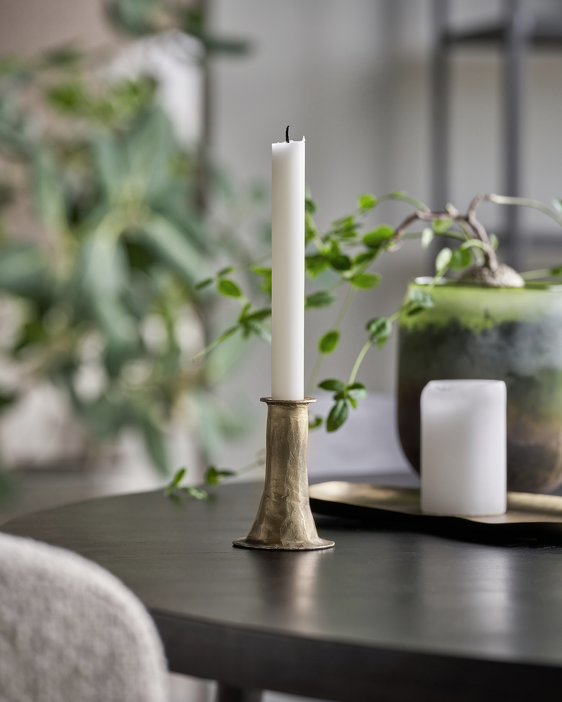 short antique gold candle holder styled on table with taper candle in calm Nordic interior
