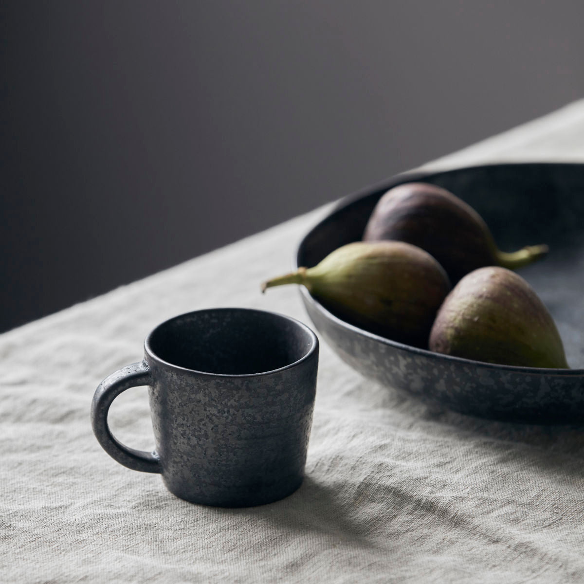 Small black brown espresso cup by House Doctor with Nordic glaze finish with pion bowl holding figs