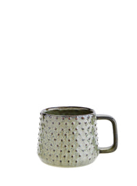 green stoneware mug with raised dot texture and earthy glaze
