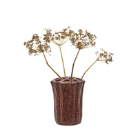 rustic stoneware vase with holes holding dried flower stems for sculptural bouquet
