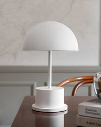 white portable dome lamp on a desk creating soft ambient light