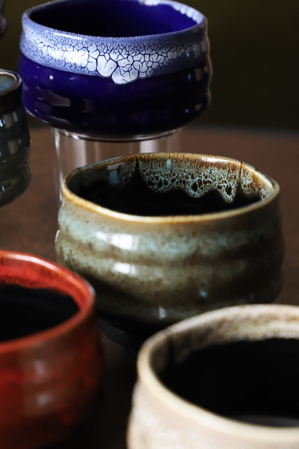 Close-up of indigo matcha bowl crackle glaze rim with other handmade bowls