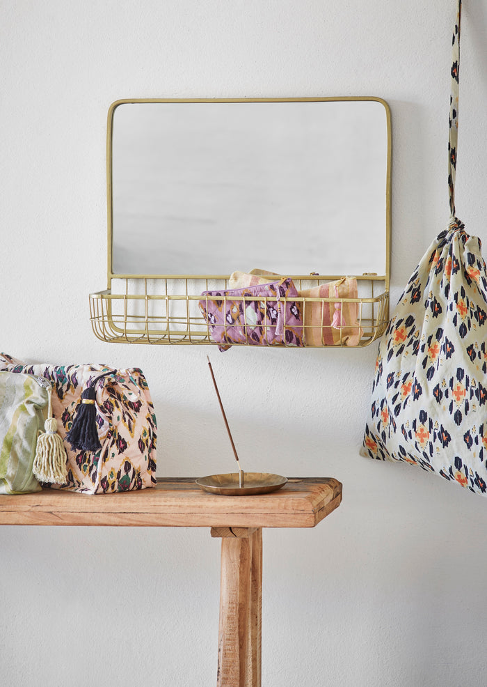 handmade antique brass iron incense holder on wood console with textiles
