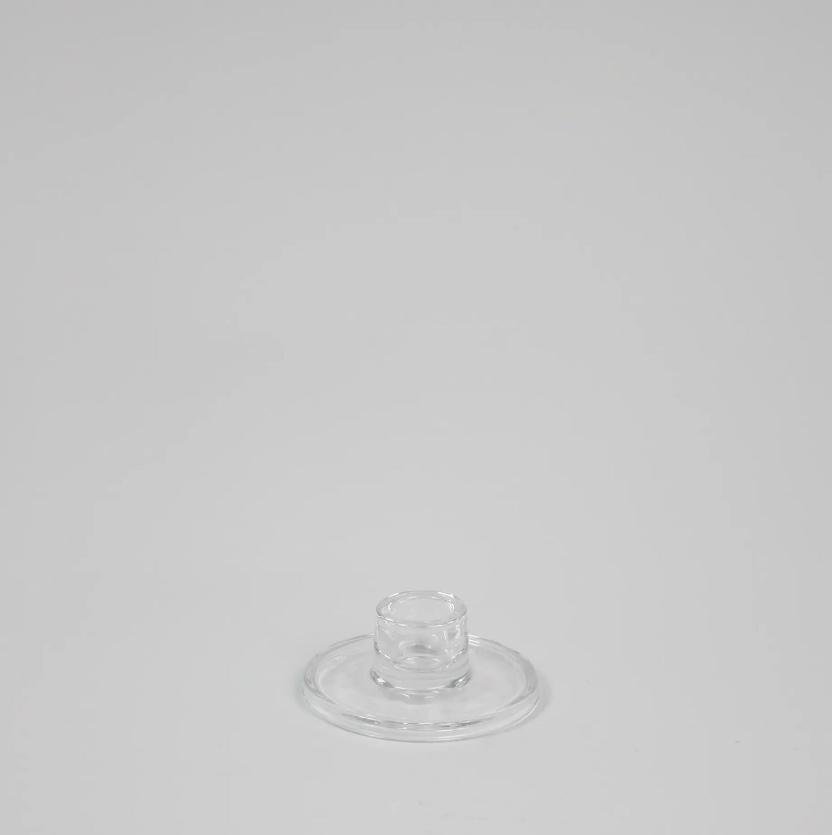 Isabella low round clear glass candle holder by Olsson & Jensen, empty, on a grey background