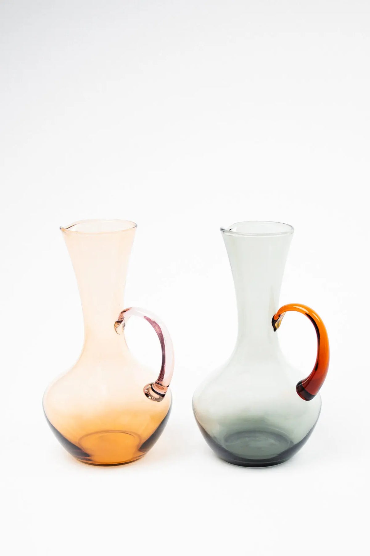 Isidora glass jugs by Olsson & Jensen in brown pink and amber grey side by side on a white background
