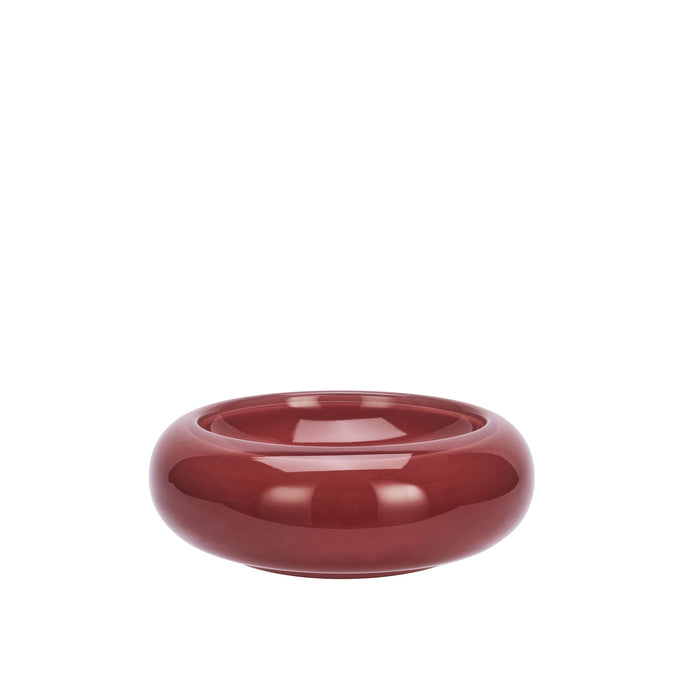 maroon round glass bowl with glossy curved design on white background
