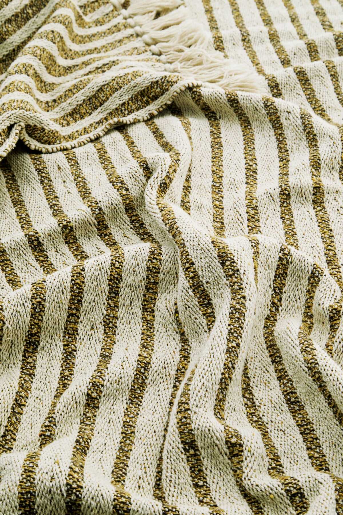 close-up of recycled cotton throw showing striped weave and colourful flecks
