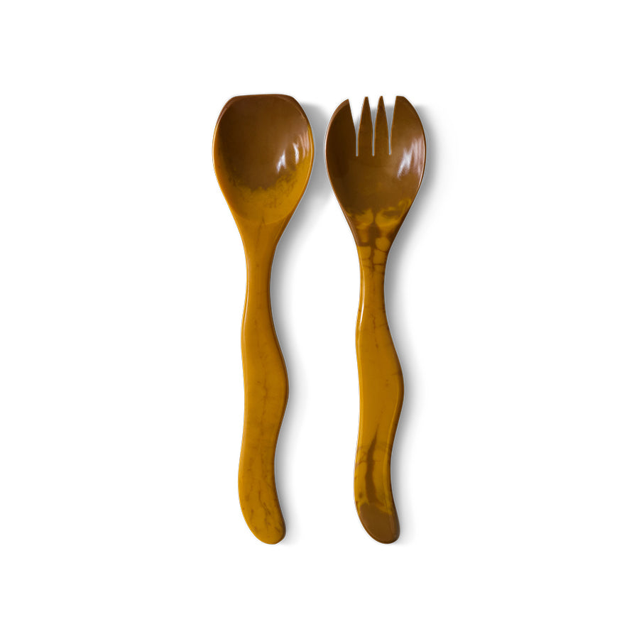 The HKLIVING ochre salad cutlery, set of 2, laid on a plain white background, showing the sculptural wavy shape of the spoon and fork